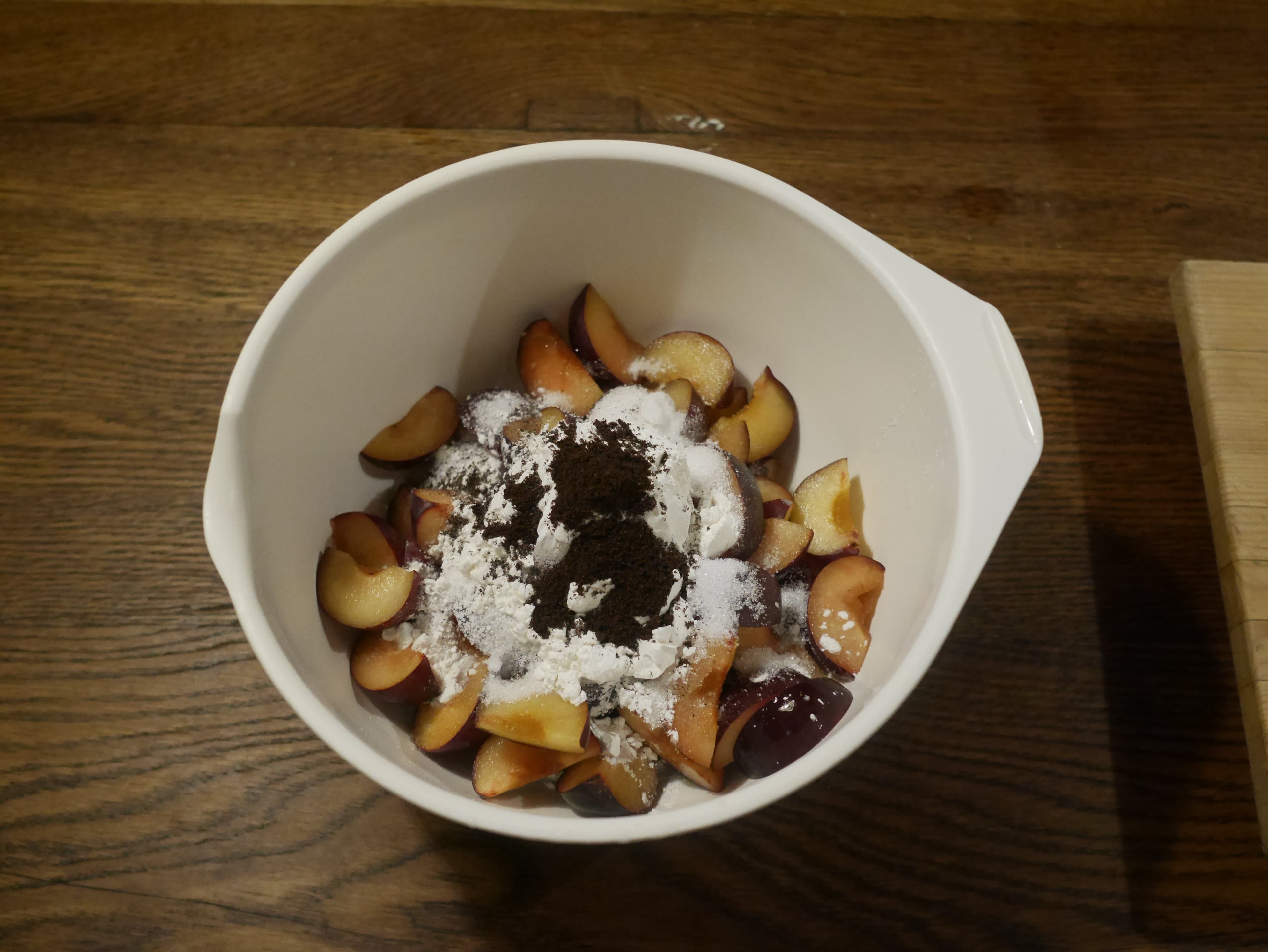 Plums, sugar, cornstarch and vanilla in a bowl.