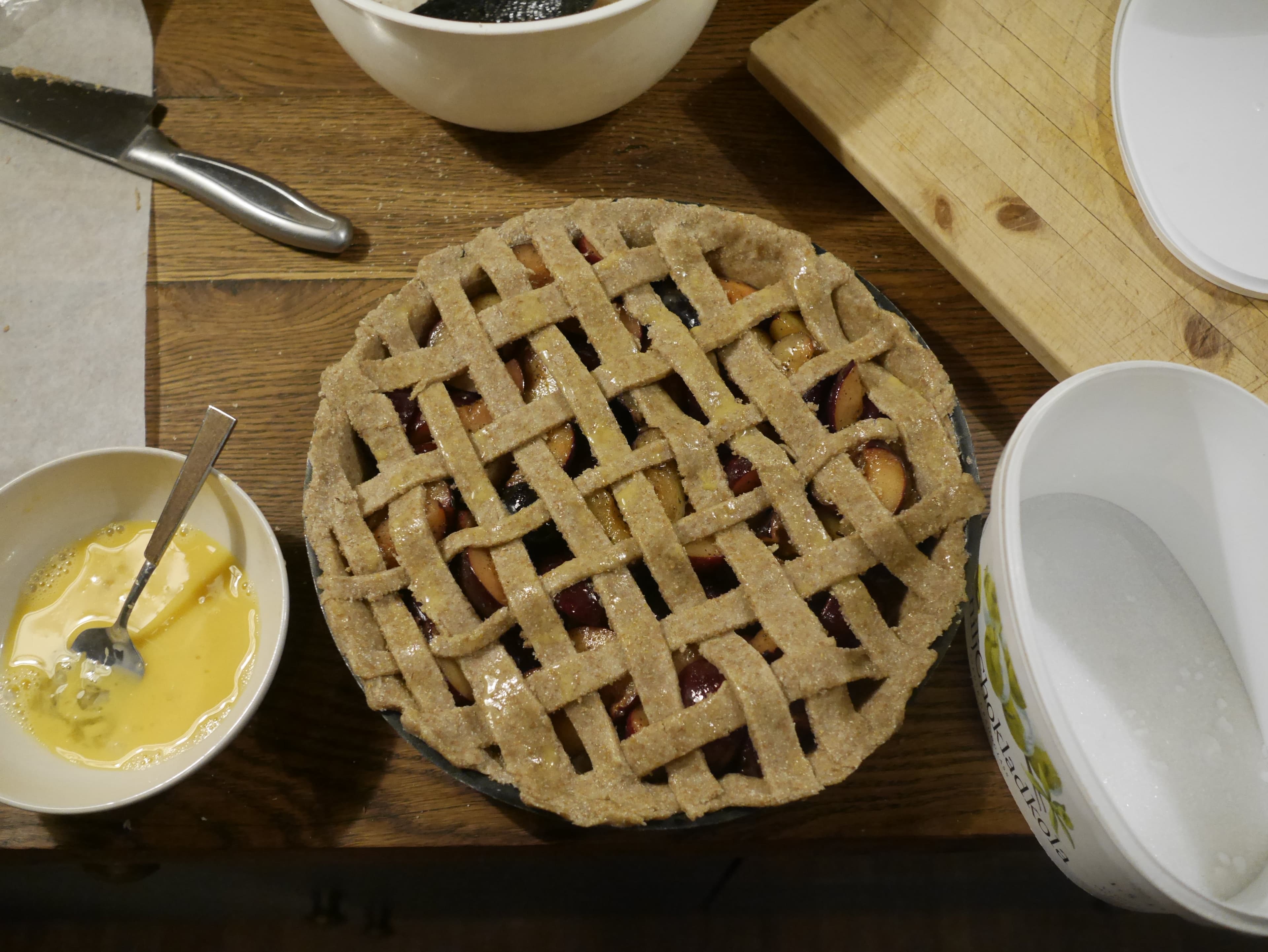 A plum pie coated in an egg wash before getting cooked.